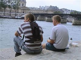 Luke and Gavin finish their lunch on the banks of the River Seine in Paris, near with Pont des Arts in the distance